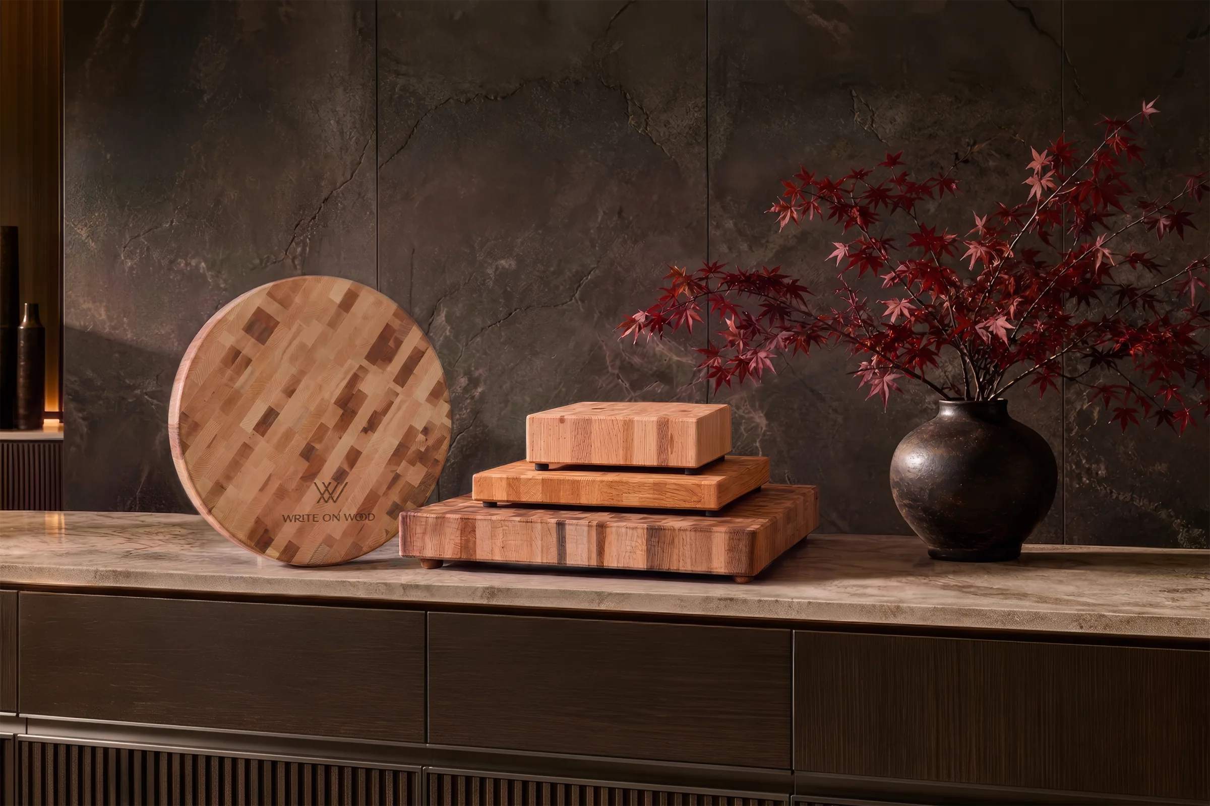 Canadian maple cutting boards displayed with red maple branches in a dark modern interior
